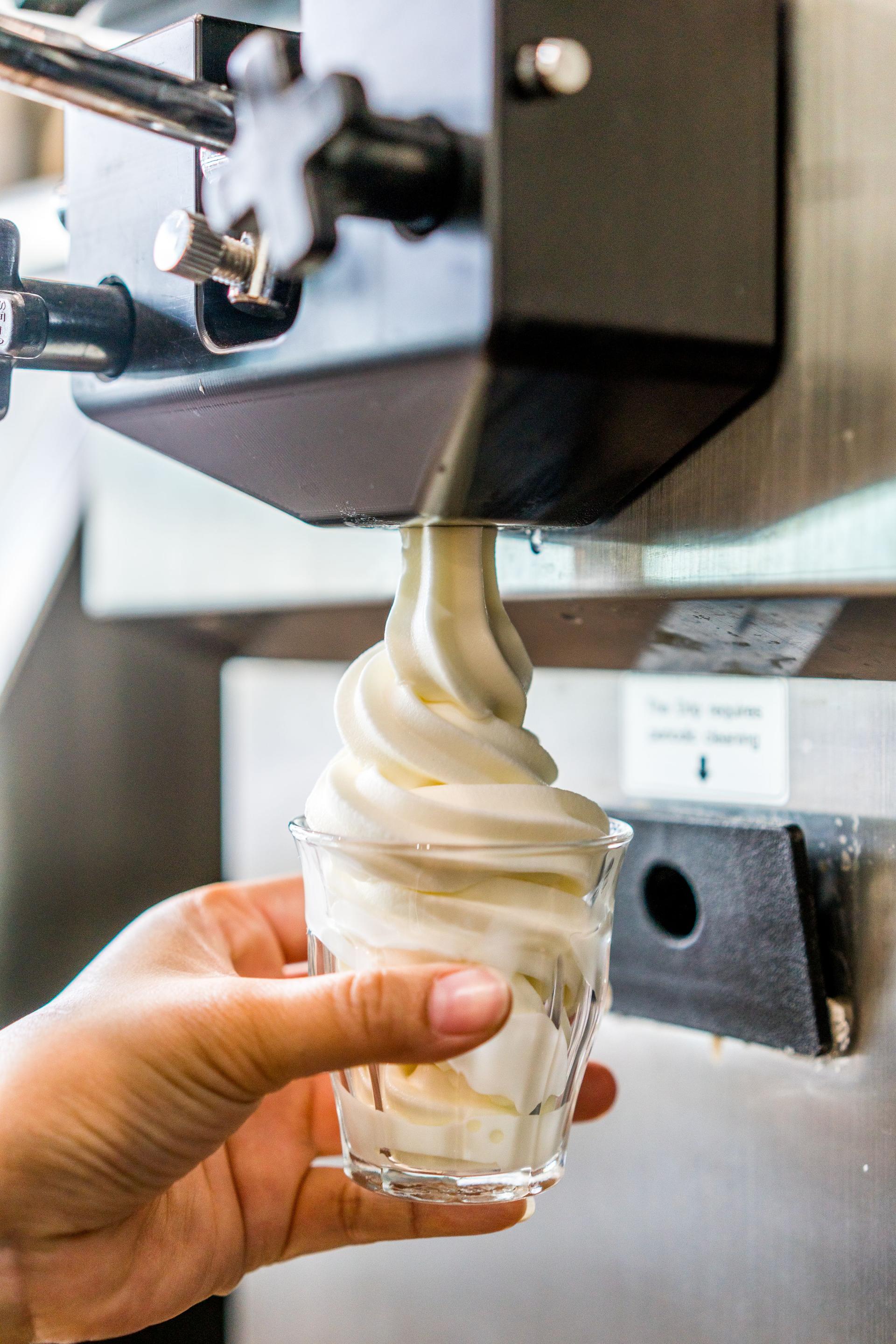 Close-Up Of Hand Holding Collecting Ice Cream In Glass